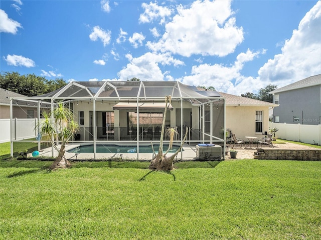 back of house with a fenced in pool, glass enclosure, a patio area, and a yard