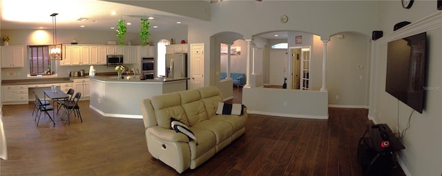 living room with dark wood-type flooring and a towering ceiling