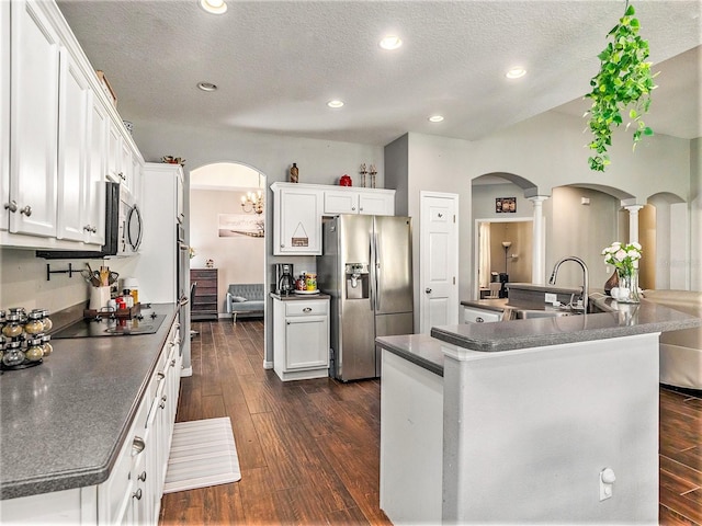 kitchen featuring white cabinets, stainless steel appliances, dark hardwood / wood-style flooring, and a textured ceiling