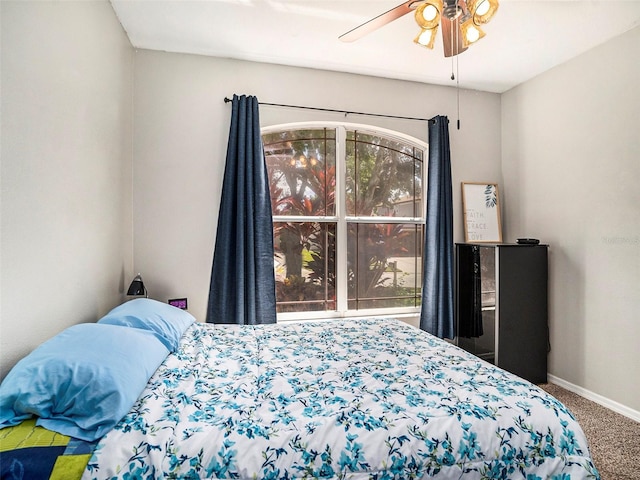 carpeted bedroom featuring multiple windows and ceiling fan