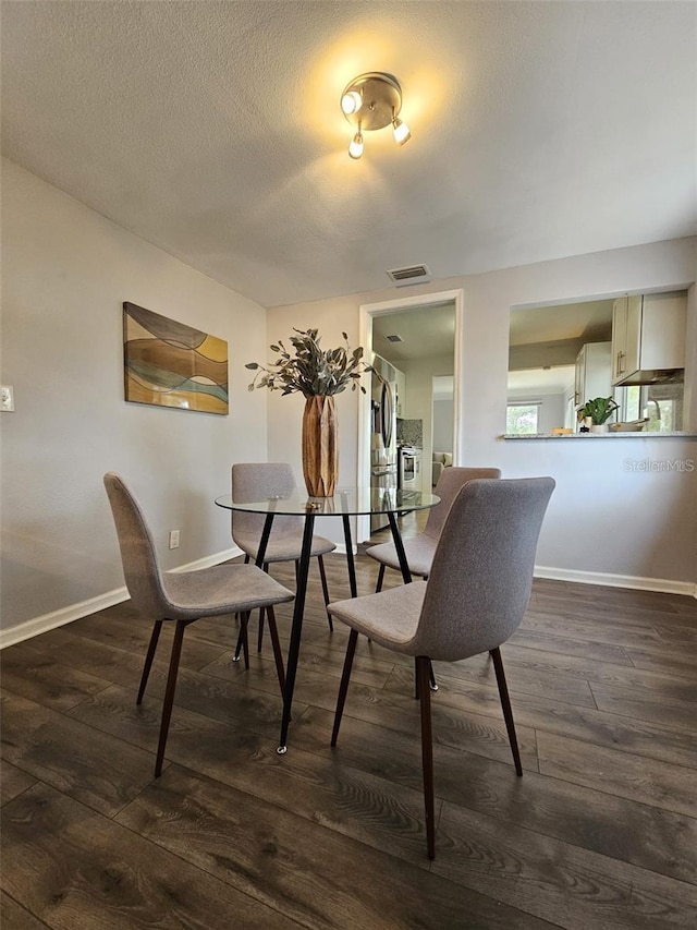 3763 Dartmouth Ave N, Saint Petersburg, FL 33713 - dining room featuring dark wood-type flooring, baseboards, and a textured ceiling