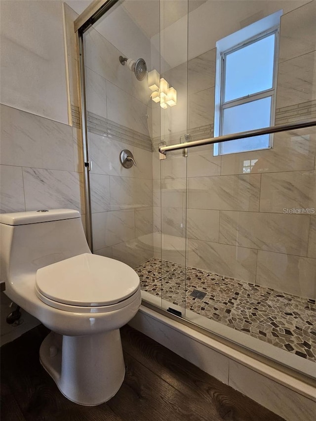 3763 Dartmouth Ave N, Saint Petersburg, FL 33713 - bathroom with a stall shower, tile walls, toilet, and wood finished floors