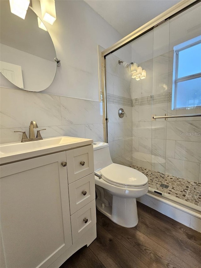 3763 Dartmouth Ave N, Saint Petersburg, FL 33713 - full bathroom with tile walls, a stall shower, wood finished floors, vanity, and toilet
