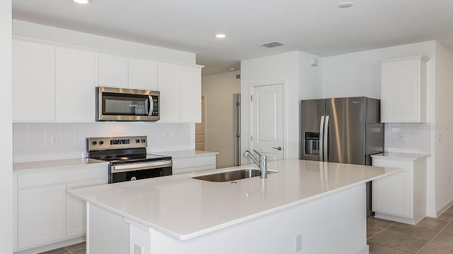 kitchen featuring stainless steel appliances, an island with sink, sink, and white cabinets