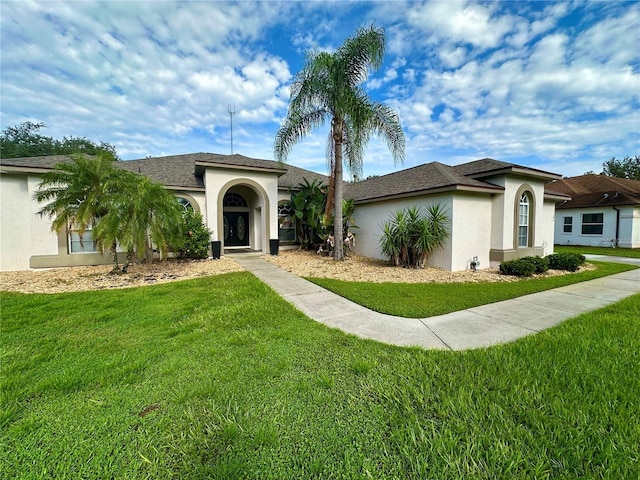 view of front of home featuring roof with shingles, a front lawn, and stucco siding