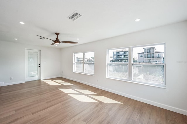 spare room featuring light wood-type flooring, visible vents, baseboards, and recessed lighting