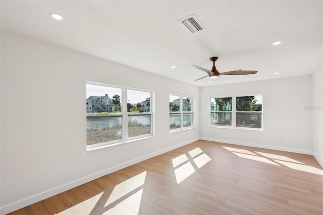 unfurnished room featuring light wood-style flooring, recessed lighting, visible vents, and baseboards