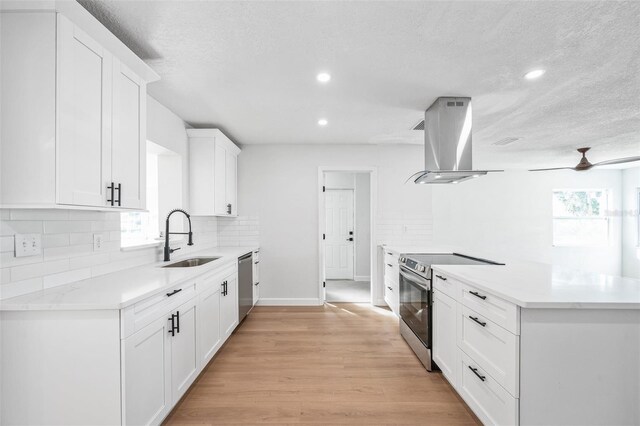 kitchen featuring a sink, stainless steel appliances, island exhaust hood, and a healthy amount of sunlight