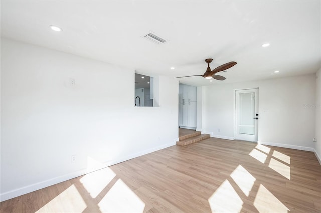 empty room with light wood finished floors, recessed lighting, visible vents, and baseboards