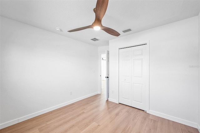 unfurnished bedroom featuring light wood-style flooring, a closet, visible vents, and baseboards