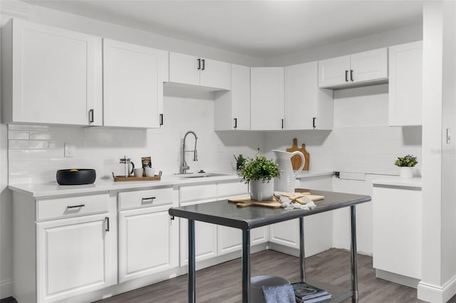 kitchen with backsplash, dark wood-type flooring, white cabinets, and sink