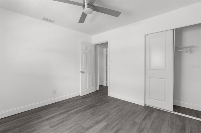 unfurnished bedroom with ceiling fan, dark hardwood / wood-style floors, and a closet