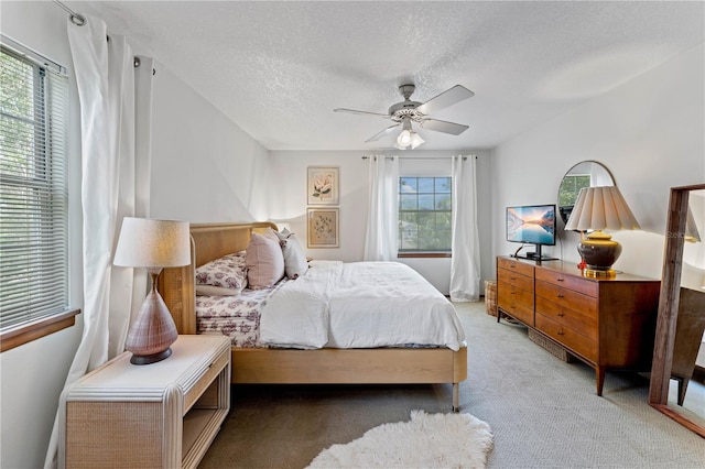 carpeted bedroom with a textured ceiling and ceiling fan