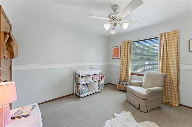 sitting room with ceiling fan and light colored carpet