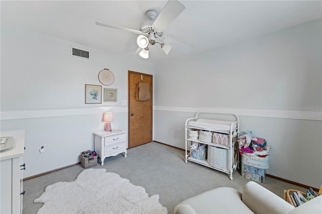 sitting room with ceiling fan and light colored carpet