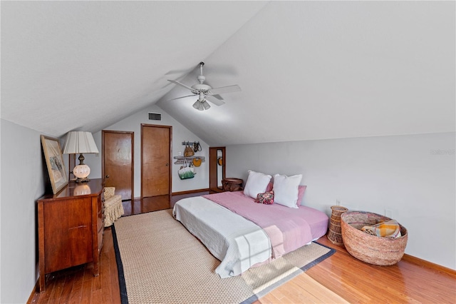 bedroom featuring ceiling fan, hardwood / wood-style floors, and lofted ceiling