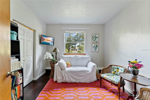 sitting room with dark wood-type flooring