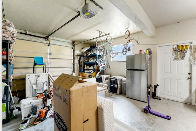 garage with washing machine and clothes dryer, stainless steel refrigerator, and a garage door opener