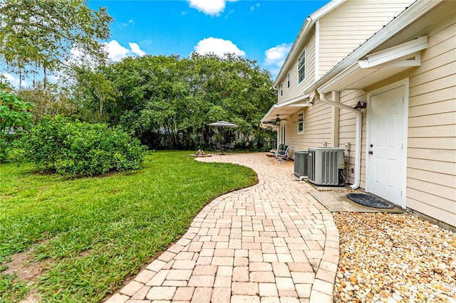 view of yard with central AC unit and a patio