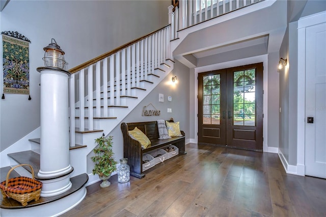 foyer with hardwood / wood-style floors, a high ceiling, and french doors