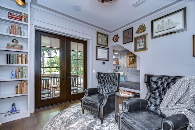 living area with french doors, hardwood / wood-style flooring, and built in shelves