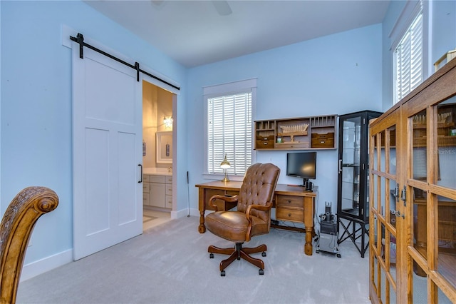 carpeted home office with a barn door and a wealth of natural light