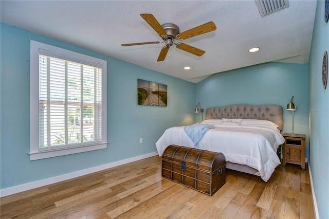 bedroom featuring a textured ceiling, light hardwood / wood-style floors, and ceiling fan