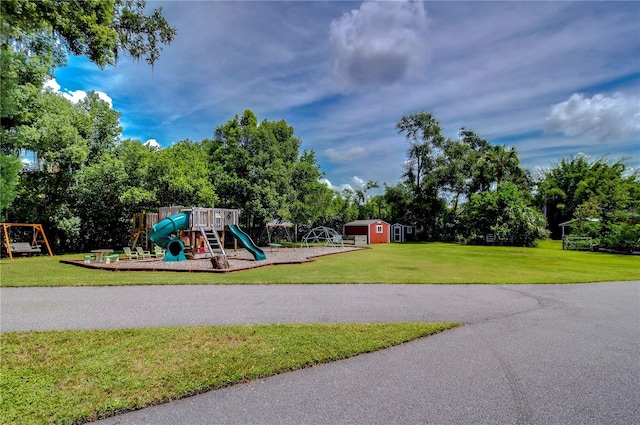 view of jungle gym with a yard and a storage unit