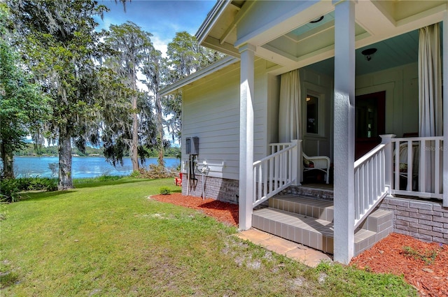 exterior space featuring a lawn and a water view