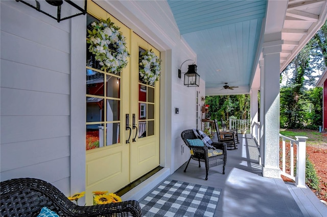 view of exterior entry featuring ceiling fan, french doors, and covered porch