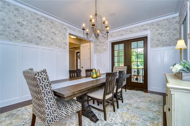 dining space featuring hardwood / wood-style flooring, an inviting chandelier, crown molding, and french doors