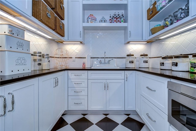 kitchen featuring white cabinets, tasteful backsplash, and sink