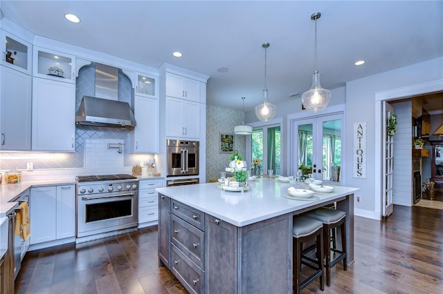 kitchen with a kitchen island, dark hardwood / wood-style flooring, white cabinetry, and stainless steel appliances