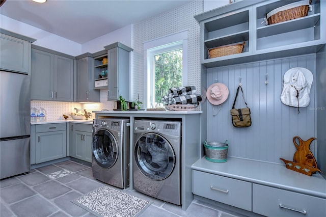 clothes washing area featuring cabinets and washing machine and clothes dryer