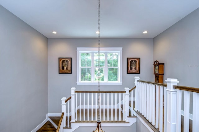 staircase with a chandelier and wood-type flooring