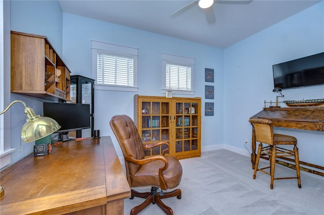 home office featuring light carpet and ceiling fan