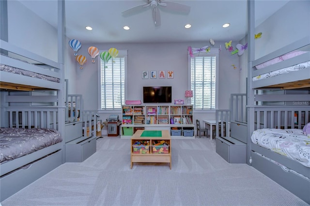 carpeted bedroom featuring multiple windows and ceiling fan