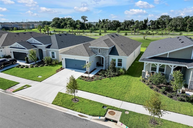 view of front of property with a garage, concrete driveway, stone siding, roof with shingles, and a front yard