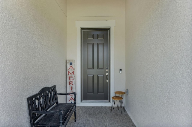 entrance to property featuring stucco siding