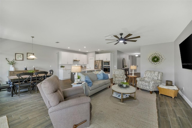 living area with recessed lighting, ceiling fan, baseboards, and wood finish floors