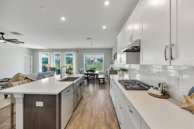 kitchen featuring light countertops, appliances with stainless steel finishes, white cabinetry, and under cabinet range hood