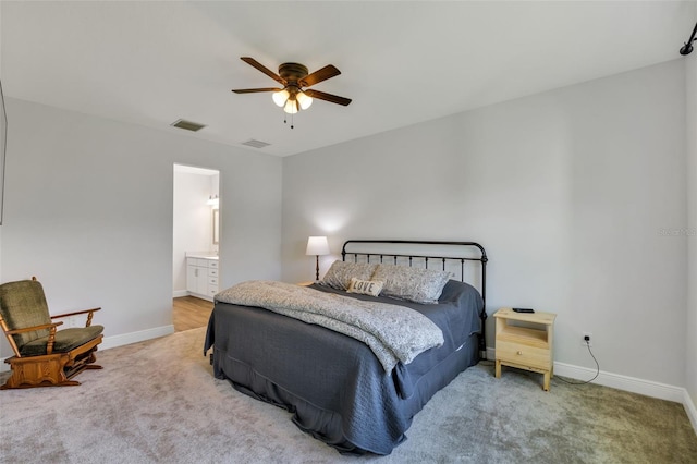 carpeted bedroom featuring visible vents, ceiling fan, ensuite bath, and baseboards