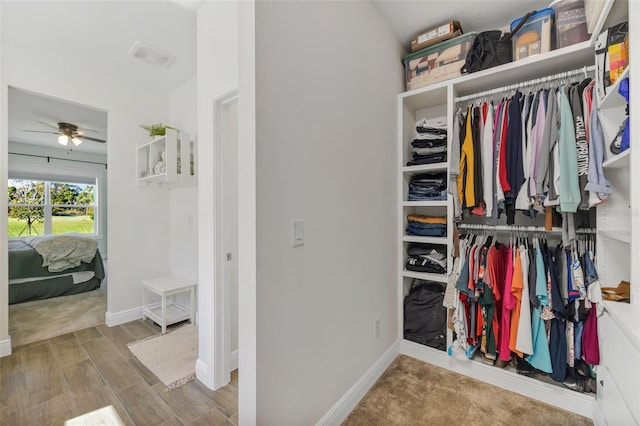 spacious closet with a ceiling fan and wood finished floors