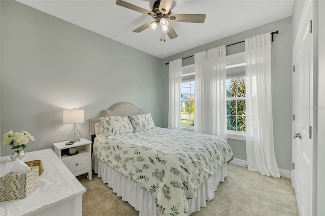 bedroom featuring a closet, light colored carpet, and ceiling fan