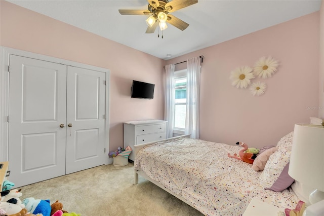 carpeted bedroom featuring ceiling fan and a closet