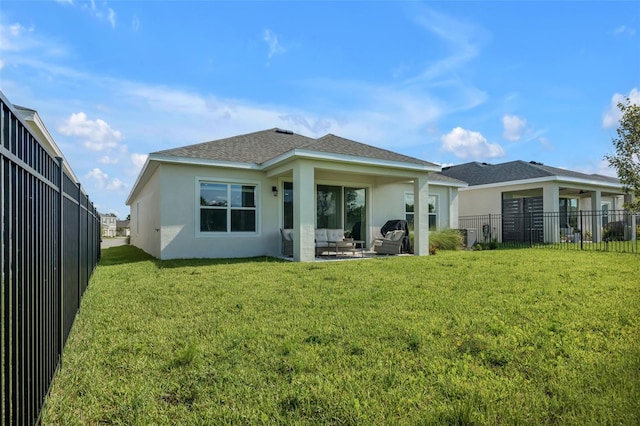 back of house with a shingled roof, a fenced backyard, a yard, a patio area, and stucco siding