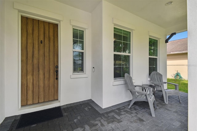 view of exterior entry featuring covered porch