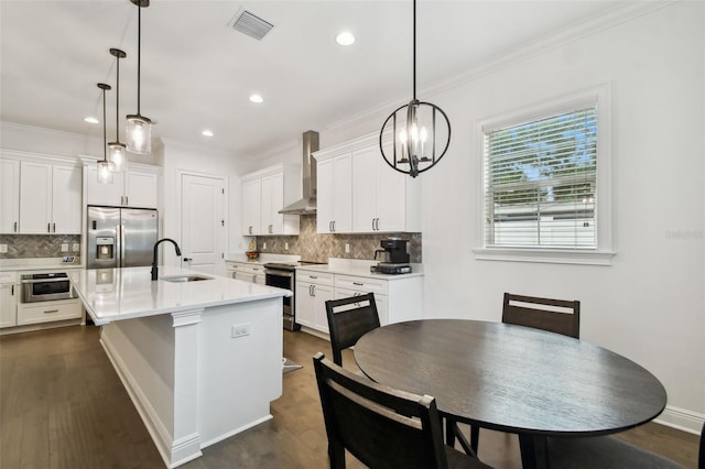 kitchen featuring an island with sink, appliances with stainless steel finishes, sink, and pendant lighting