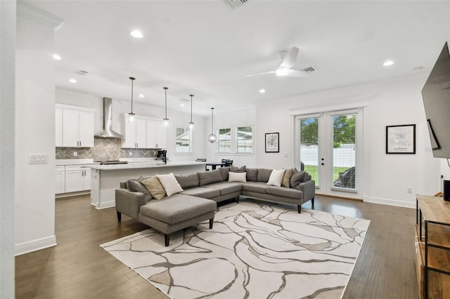 living room with ceiling fan, dark wood-type flooring, and crown molding