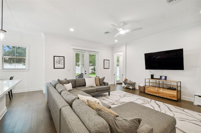 living room featuring dark wood-type flooring, crown molding, and ceiling fan